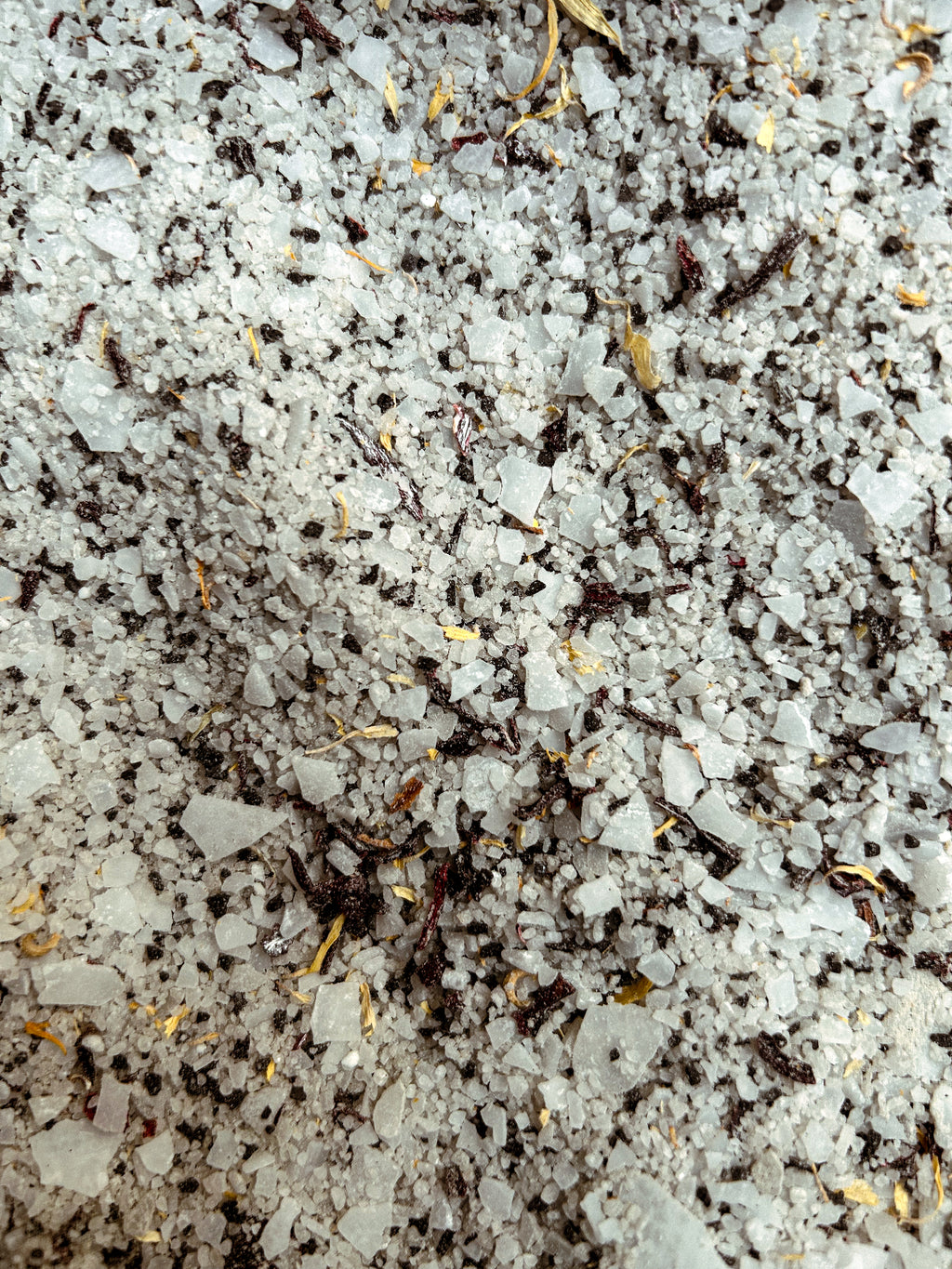 Close-up shot of Honey Noon bath soak with dried hibiscus and calendula. 