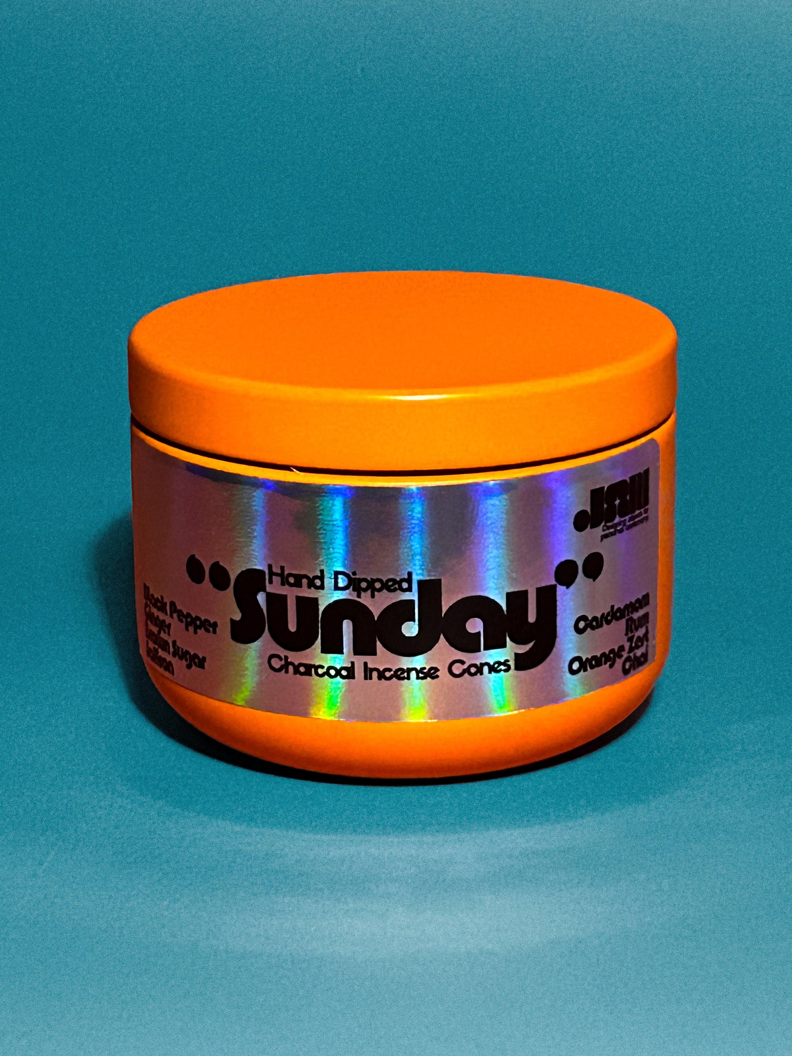 Orange container with 'Sunday' scent hand dipped charcoal incense cones branding on a blue background