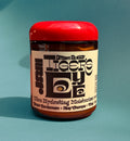 Jar of Dream Butter Tiger's Eye Ultra Hydrating Moisturizer on a teal background