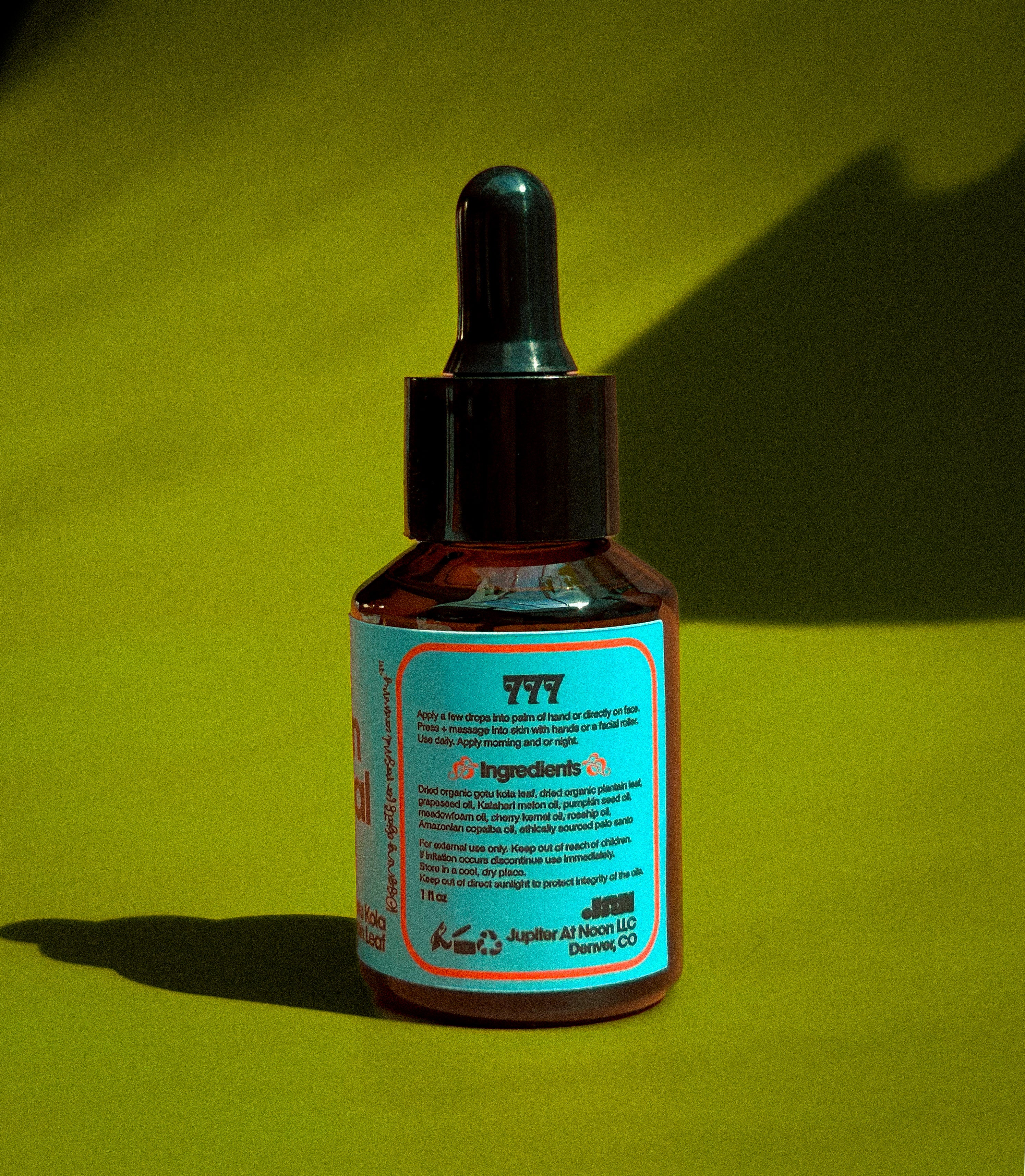 Bottle of Triple Seven Herbal Face Oil on a green retro color grading background back label view.