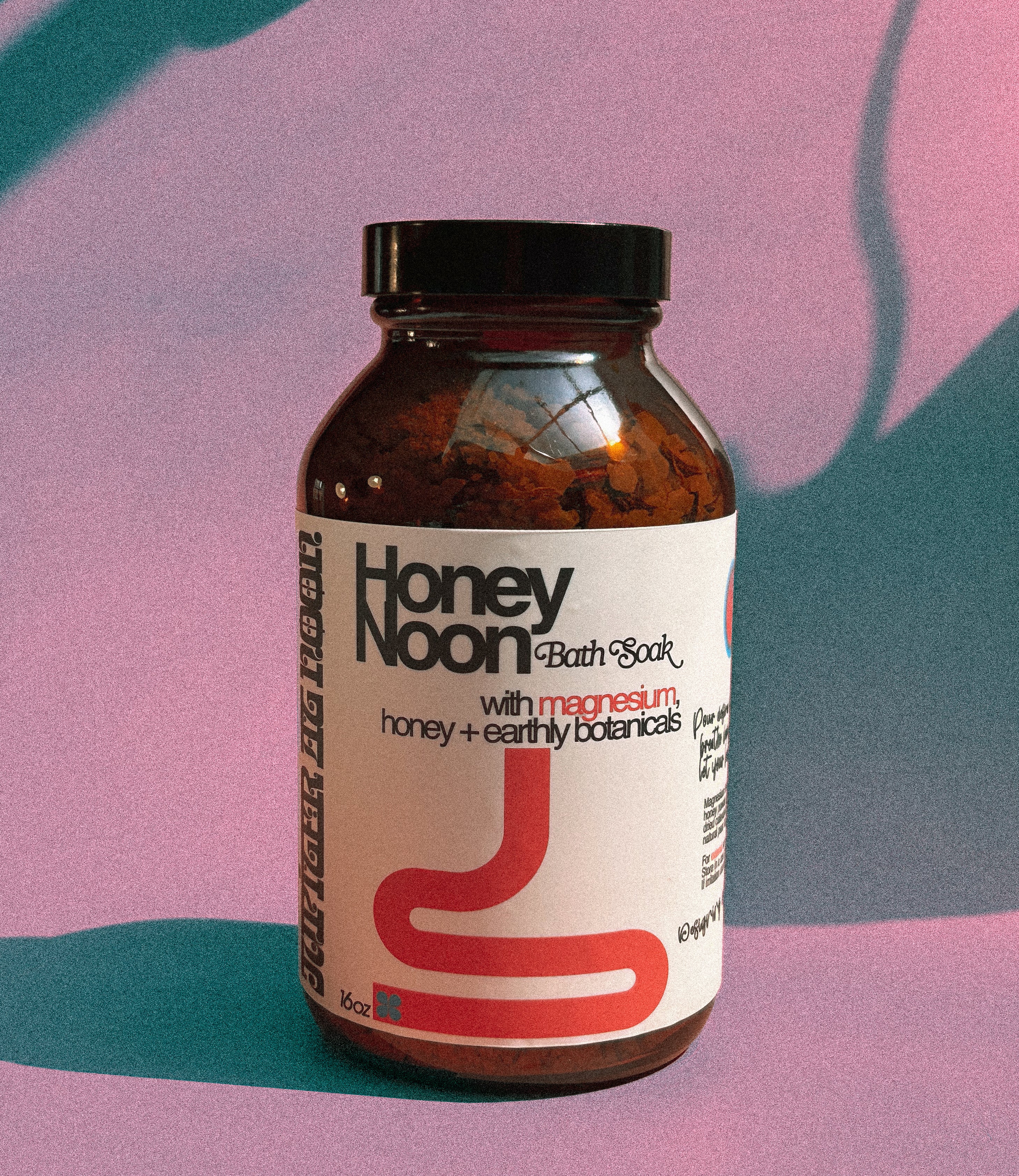 Bottle of Honey Noon Bath Soak with a colorful abstract background